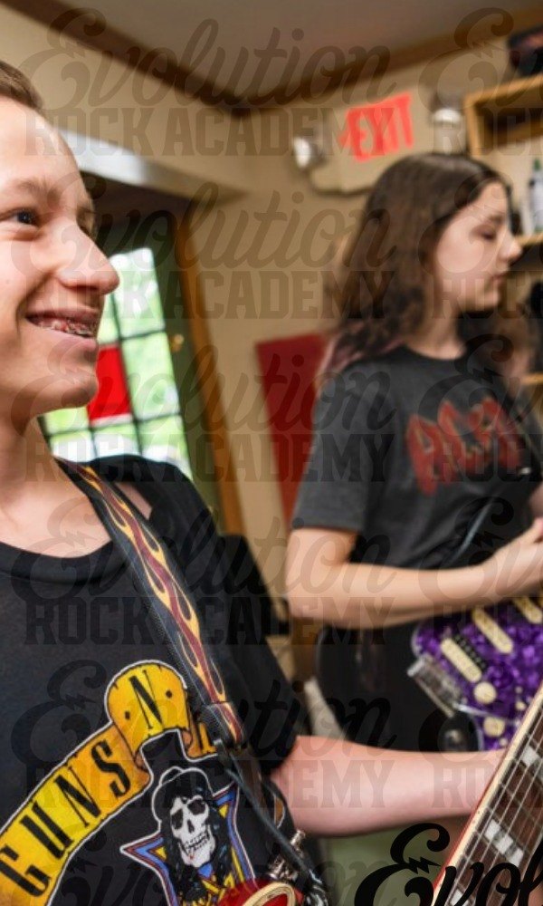 Two teenage guitarists rehearsing together in a practice room